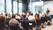 © Jhati - Blurred audience members attentively listening to a speaker at a corporate conference event setting