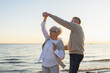 © Юлия Завалишина - Keep moving. Romantic senior mature couple dancing together on beach outdoor recreation. Happy smiling family retired man woman husband wife having fun enjoying time together. Family moment love care
