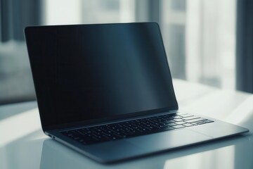 Poster - Laptop on a sleek desk with natural light streaming in from a nearby window during a quiet early morning