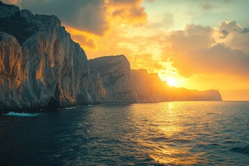 Fototapete - Glistening ocean waves reflect the warm sunset over rugged cliffs at the coastline, creating a serene and picturesque evening atmosphere