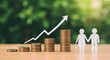 © abu - Financial Growth Concept Stacked Golden Coins Representing Increase and Paper Cutout Couple on Light Brown Wooden Surface