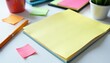 © Pimchada - High angle view of colorful notebook, pens and sticky notes on white desk, workspace, stationary