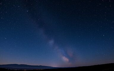 Wall Mural - vibrant starlight illuminates the dark blue night sky, showcasing the milky way stretching across th