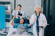 © ARMMY PICCA - Nurse giving assistance to senior patient with disease in bed. Medical assistant and doctor doing healthcare checkup for pensioner with oxygen tube and IV drip bag in hospital ward.