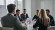 © abu - Business Meeting in a Bright Conference Room with Team Collaborating Around a White Table in Suits