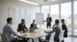 © abu - Blurred View of Business Team Brainstorming Meeting Around a Table in Bright Conference Room