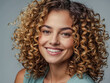 © Kasper - Radiant woman with curly hair smiling confidently in a professional setting.
