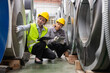 © Washburn - A female engineer is inspecting steel plates in a factory.