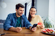 © baranq - Happy couple shopping online at home together using credit card and smartphone