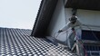 © phonix_a - Two men painting a roof of a house .