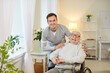 © Studio Romantic - Portrait of happy young friendly male social worker with joyful senior elderly disabled man with disability sitting in wheelchair. Cheerful nurse or caregiver with handicapped patient in nursing home