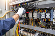 © A Stockphoto - Checking the electrical system, an electrician is using an electric meter to check the electrical system at a control cabinet. for safety