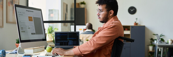 Fototapete - Header of young multiethnic man with disability sitting in wheelchair and typing on keyboard while using AI image generator