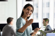© fizkes - Friendly young Hispanic recruiter woman inviting job candidates to join team. Happy businesswoman welcoming customers, partners for consultation, making hand invitation gesture, smiling at camera