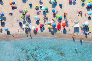 Wall Mural - aerial view of colorful umbrellas on sandy beach, swimming people in blue sea at sunset in summer. s
