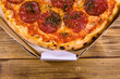 © ihorbondarenko - Pizza with salami sausage and parmesan cheese in cardboard box on a wooden table. Top view