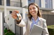 © fizkes - Smiling professional real estate agent, property manager, or consultant, look at camera, holds set of keys, as symbol of investment opportunity, relocation, buying, renting, or leasing modern property