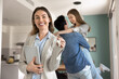 © fizkes - Portrait of young professional real estate agent holding tablet and keys, symbol of successful property deal, joyful couple embracing, celebrating buying new house. Homeownership, real estate purchase