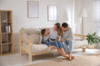 © New Africa - Happy family with little daughter sitting on sofa in living room