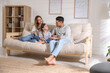 © New Africa - Happy family with little daughter sitting on sofa in living room