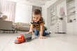 © New Africa - Little boy playing with toy car at home, low angle view