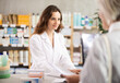 © JackF - Woman consultant at pharmacy sells medications to client for treatment of chronic disease. Employee at counter with computer serves patient