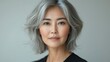 © Ramlan - Elegant woman, gray hair, short wavy style, neutral background. Close up portrait, gentle expression