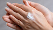 © noz-studio - Close-up of hands applying moisturizing cream for soft, hydrated, and healthy skin.