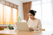 © Monster Ztudio - Beautiful young Asian woman working with laptop computer in living room. Work at home