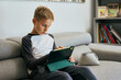 © alvaro - Young boy using digital tablet on sofa at home