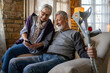 © NDABCREATIVITY - Happy bonding older married couple relaxing, laughing, enjoying leisure time together at home.