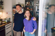 © Westend61 - Couple in a kitchen with communication cables smiling at the camera