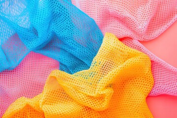 Colorful mesh fabric in blue, yellow and pink on pink background. Great for designs needing texture or abstract colorful backgrounds.