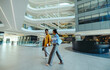 © Jacob Lund - Two female corporate professionals walking in modern office lobby