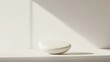 © wicha - A minimalistic white background featuring a floating geometric shape with soft shadows.