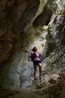 © Xalanx - Woman hiker standing inside a narrow rocky canyon looking up.........