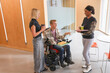 © Caia Image - Man in wheelchair and coworkers in office