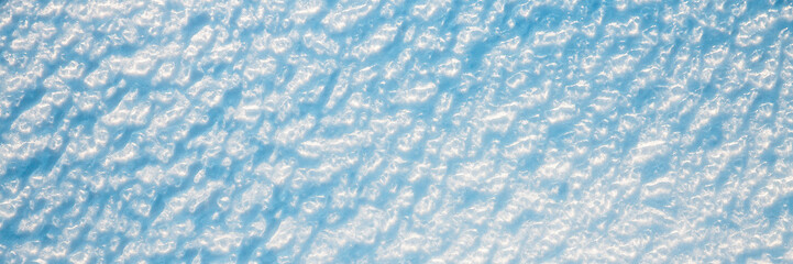 Wall Mural - beautiful winter background with snowy ground. natural snow texture. wind sculpted patterns on snow 