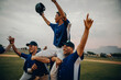 © Jacob Lund - Baseball team celebrating victory with captain raised on shoulders of teammates