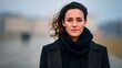 © GreatStockPics - A woman stands confidently in a black scarf and coat, with a beautiful natural backdrop. The foggy atmosphere adds depth to her expression, highlighting her poise and beauty