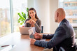 © gzorgz - Group of business people sitting in a modern office and working on laptops
