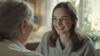 © Lumos Studio - Young woman smiling while talking to senior for intergenerational bonding and caregiving themes