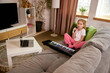 © master1305 - Little girl sitting on sofa with microphone singing while watching online lesson on laptop, learning music performance online. Concept of childhood, online education, remote studying