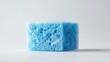 © Ariestia - A single blue cleaning sponge sits against a white background