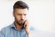 © Prostock-studio - Computer Problem. Concerned Millennial Businessman Talking On Cellphone With Customer Support, Having Troubles With Laptop Or Internet Connection At Workplace In Office, Suffering System Error