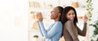 © Prostock-studio - Cheerful black girlfriends singing and dancing, having fun together at home