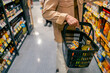 © CandyRetriever  - Asian man holding supermarket shopping basket choosing, checking price, buy food and grocery on shelf at supermarket in shopping mall. People enjoy urban lifestyle travel and shopping in the city.