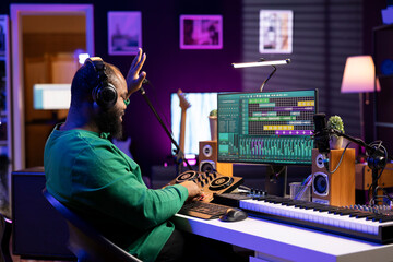 Aufkleber - African american music producer counting down before starting a recording session, operating on mixing console and professional editing software. Sound engineer producing songs in home studio.