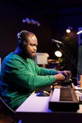 Aufkleber - African american music producer twisting knobs on mixing console, producing new tracks with sound effects. Artist composing songs in post production, operates on digital software in home studio.