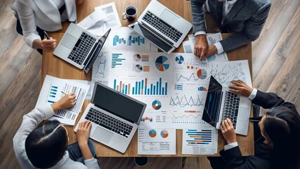 Poster - Overhead shot business meeting four people analyzing charts , graphs wooden table. Laptops are open, , coffee cup is visible. The focus is collaborative data analysis business strategy.
